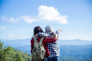 Travelers, young women, look at the amazing mountains and forests, wanderlust travel ideas, space for messages, great moments of the atmosphere.